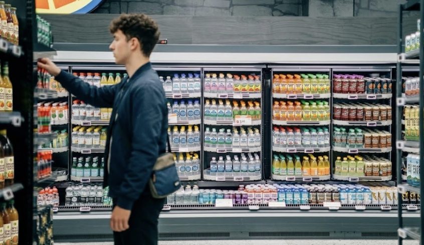 Customer browsing well-stocked refrigerated shelves